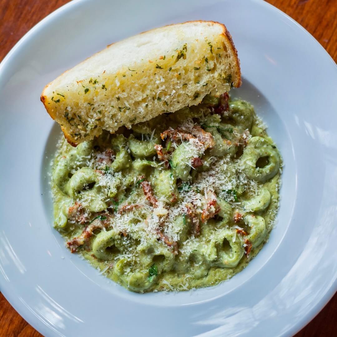 A plate of pesto tortellini.